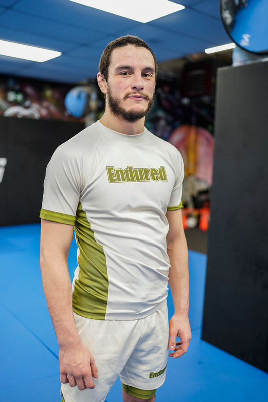 Cream and green block logo rashguard